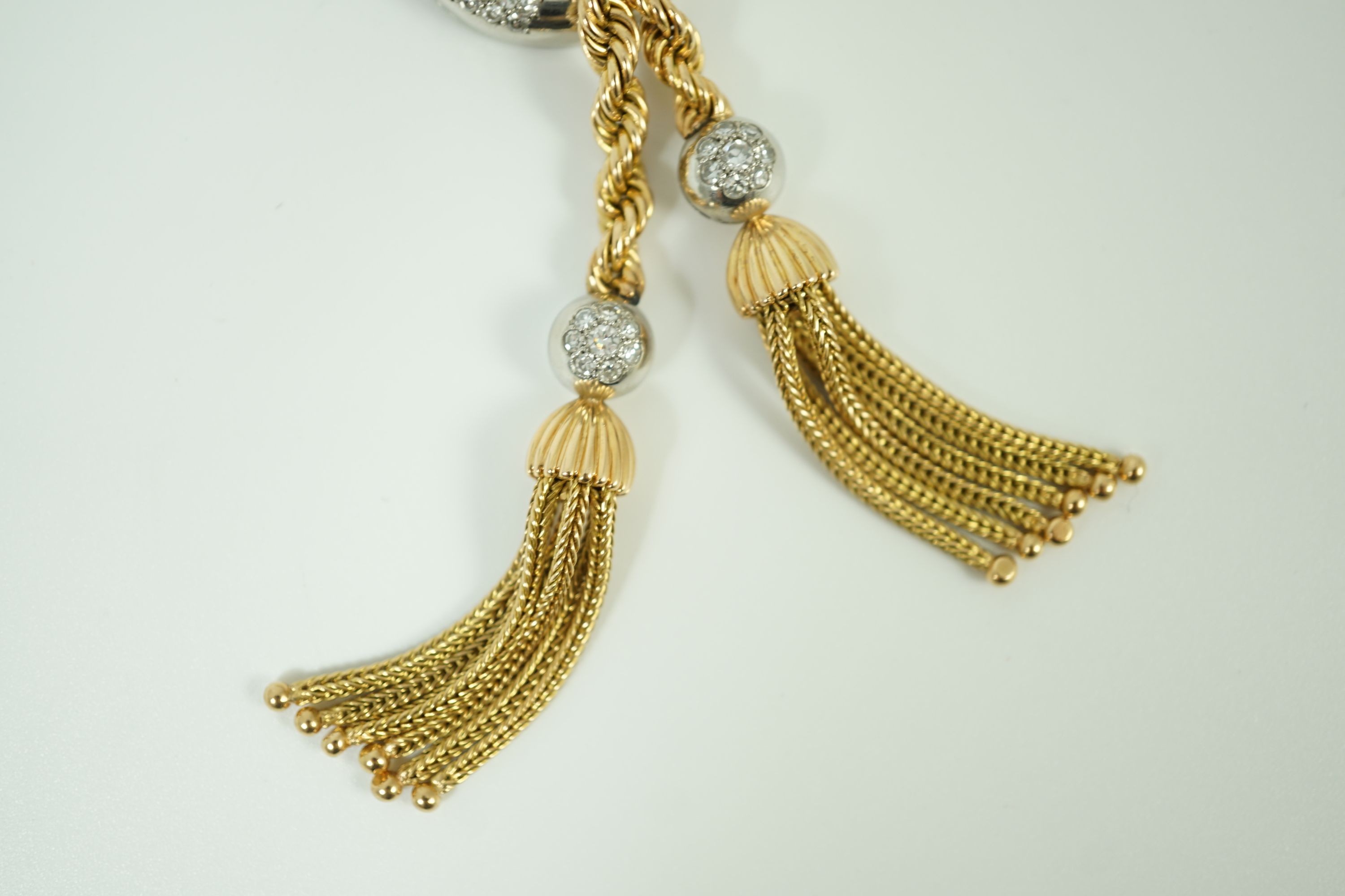 A modern heavy Middle Eastern gold and diamond set rope twist drop tassel necklace, together with a similar gold and diamond set bracelet